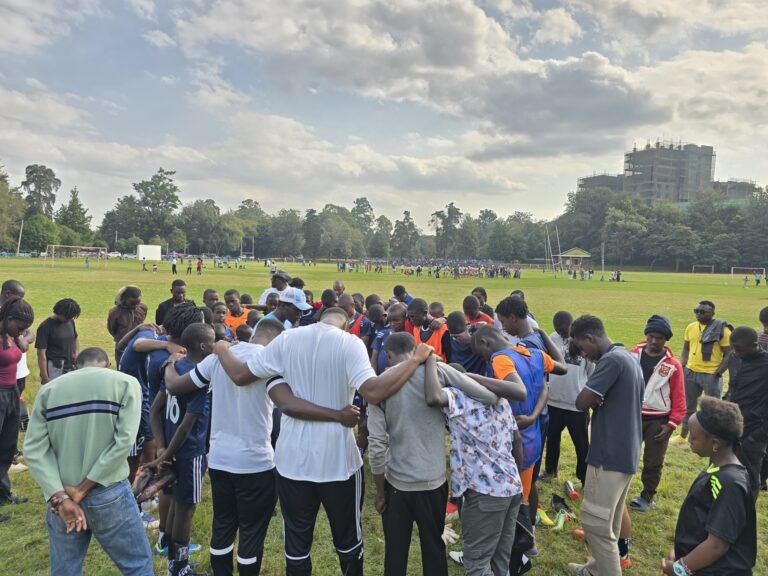 Kisasa FC players, coaches and opponents gather in a post-match circle after the Diamond Youth Football League final, 28 June 2026.